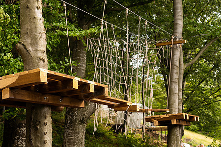 在绳索公园安全设备中徒步登上绳子攀爬中心绳索平衡活动环境风险危险树梢闲暇森林冒险图片