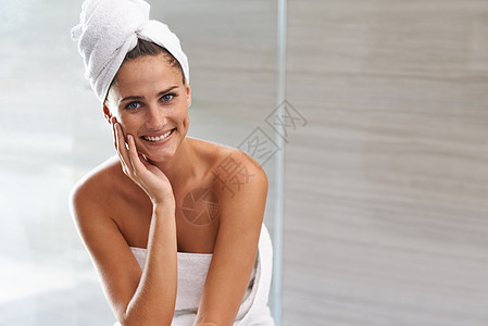 洗完澡后很奢华 一个漂亮的年轻女人的肖像 她坐在浴室里用毛巾裹着毛巾图片