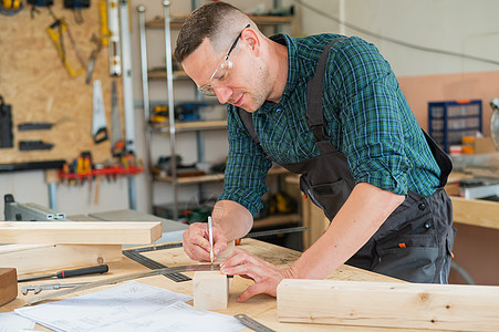 木匠测量木板 在车间用铅笔作记号标记作坊工具木工统治者建设者工艺木制品工作男人控制板图片