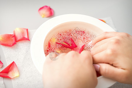 女性手握一碗水 在温泉里用粉红花瓣接着玫瑰花疗法芳香女孩程序装饰生活润肤手指风格奢华图片