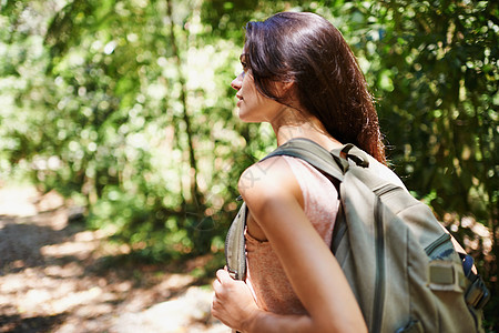 竹林小道享受大自然的静态 一个年轻女子在森林里漫步背景