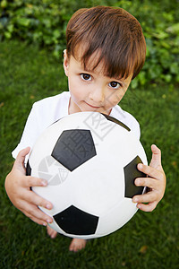 后院足球 一个甜美的小男孩在后院里踢足球训练前院花园孩子们乐趣青年娱乐活动院子男性图片