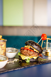 黑汉堡包加牛肉肉和薯条面包午餐洋葱食物小吃美食包子芝麻油炸晚餐图片