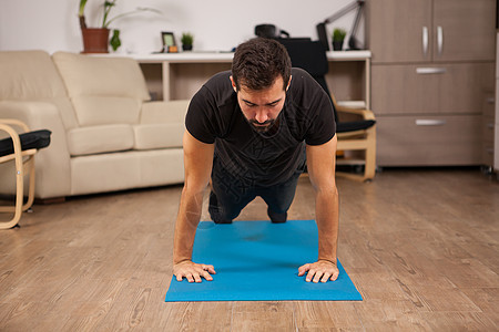 长胡子的男子在他的房子地板上推高体操身体训练男性地面男人运动肌肉纪律活力图片