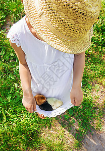 孩子手里握着一只鸡 有选择的专注帽子婴儿拥抱花园女孩新生儿生活朋友们食物橙子图片