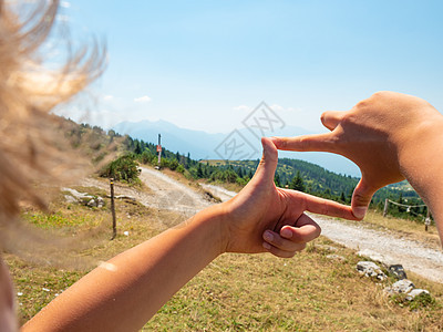 男孩们在山峰的砂砾路上用木木观光标志图片