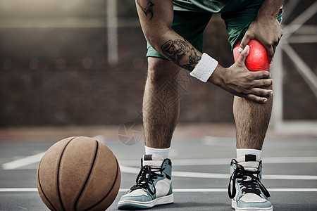 运动 篮球受伤和膝盖疼痛或运动员男子在户外球场上训练或锻炼时握住受伤的腿 男性手在发光的红色身体部位上的特写背景