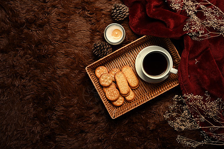 上面是芳香蜡烛 木质餐具和咖啡杯以及毛绒地毯上的饼干图片