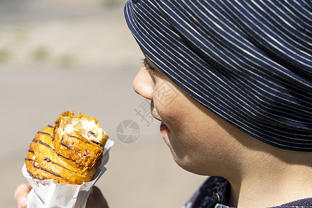 一个开心快乐的男孩 正在街上吃面包男性食物乐趣甜食饮食童年午餐青年营养垃圾图片
