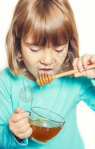 孩子吃蜂蜜 有选择的焦点治疗幸福孩子们微笑女孩传统食物水果维生素甜点图片