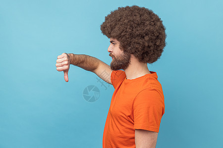 不高兴的男人的侧面观点 显示拇指下不喜欢的手势 代表不同意见图片