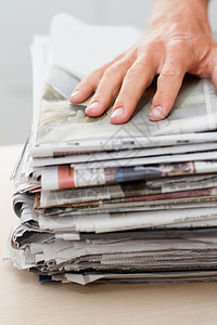 减少 再利用 回收 在一堆报纸之上的一只手图片