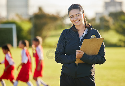 足球场 女教练和女队在背景中的草地上训练 体育 青年发展和团队合作 一个快乐的年轻女志愿者执教足球队 带来自巴西的剪贴板图片