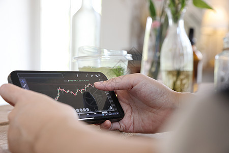 女性手用智能手机在咖啡店进行在线证券交易所交易 商业理念女士投资者图表贸易投资生长互联网金融营销市场图片