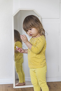 迷人的婴儿怀疑地检查镜子附近一些小曲子图片