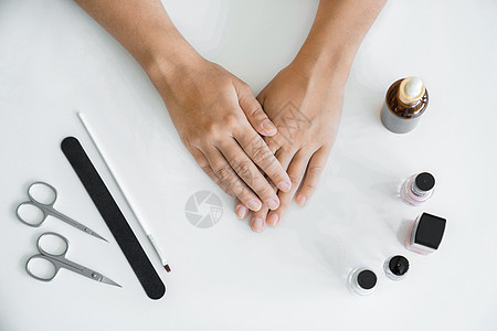 手部护理的概念 在开始修指甲之前 没有修指甲的女性手放在桌子上 双手特写 美甲配件躺在她旁边的桌子上图片