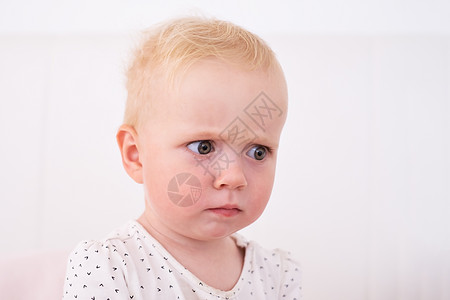 迷惑不解的婴儿皱眉脸看着一旁 试图回忆她把玩具放在哪里图片