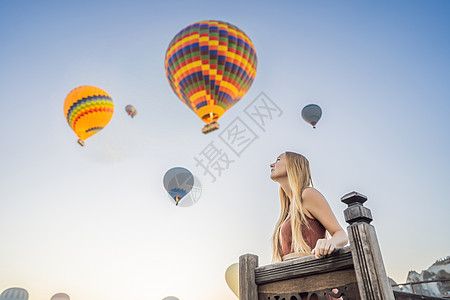 坐热气球女孩在土耳其卡帕多细亚看热气球的女游客 土耳其概念中的快乐旅行 山顶上的女人享受美妙的景色男人航班冒险气球假期家庭天空空气女士地标背景