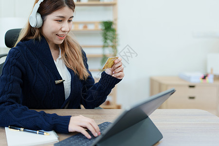 在线购物和互联网支付 美丽的亚洲女性正在使用信用卡和平板电脑笔记本电脑在线购物或在数字世界中办事网络幸福互联网卡片金融商业店铺手图片