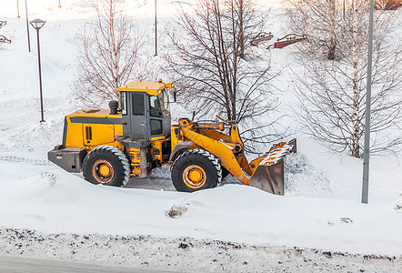 清理雪地 拖拉机在大雪降雪后扫清了道路打扫工作人行道天气街道暴风雪服务橙子行动城市图片