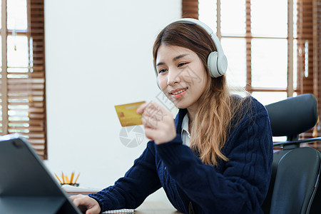 在线购物和互联网支付 美丽的亚洲女性正在使用信用卡和平板电脑笔记本电脑在线购物或在数字世界中办事互联网卡片商业成人享受零售网上购图片