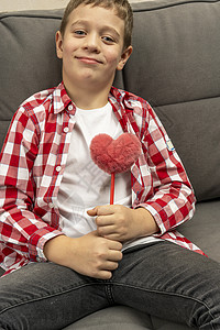 感恩的心一个男孩 一个毛茸茸的心形玩具爱心衬衫格子礼物t恤男生沙发感恩孩子照片背景