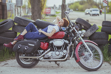 女汽车修理工躺在摩托车上运输机械作坊发型服务工作服女士耐力赛喘息女性图片
