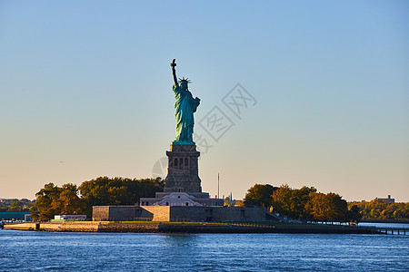 以柔软的金光照着自由女神像的岛屿 左侧装满了光图片