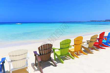 位于阿鲁巴杜斯加勒比的阿鲁巴白沙滩上多彩色木制椅子帆船家具海岸线旅游目的地假期蓝色海景文化积水图片
