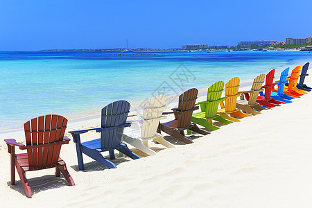 位于阿鲁巴杜斯加勒比的阿鲁巴白沙滩上多彩色木制椅子天空热带海滩海景水湾休闲椅帆船假期躺椅旅游图片