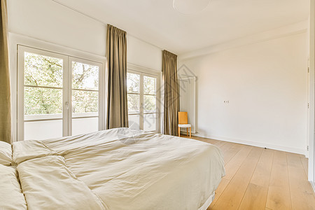 主卧室有一张大床和大窗窗户背景图片