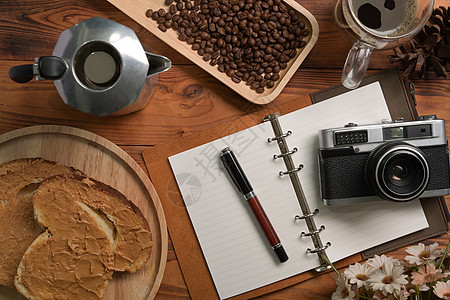 莫卡锅 笔记本 相机和木制桌上的花生酱三明治图片