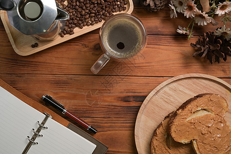 一杯热咖啡和花生酱三明治 在木制桌上图片