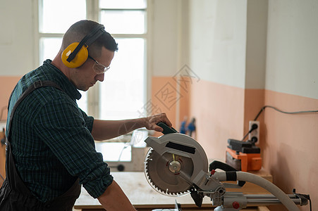 师傅用在讲习班上看到的通告切板工人灰尘工厂纺纱建设者刀刃技术员乐器木头男人背景图片