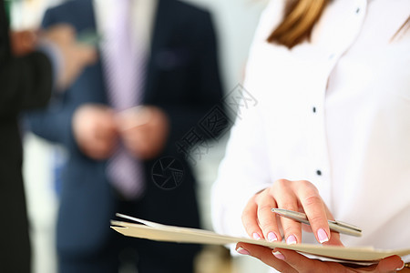 妇女手持证件 在商业人士的背景背景中笔记;图片