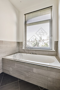 用窗户在浴室的洗手间里用一个大浴缸图片