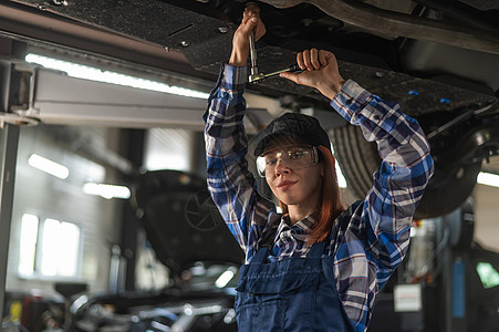 女机械师把车底的坚果解开 一个女孩在男人工作时被吊起来了男性车站引擎女孩检查作坊机器修理工替代品技术员图片