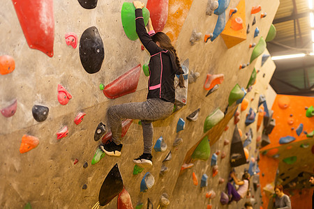 女孩在室内实际墙壁上攀爬 巨石训练运动解雇岩石健身房操场安全活动娱乐活力登山者图片