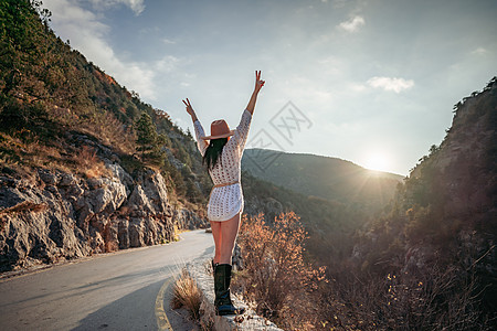 穿着棕帽子和白色毛衣的女旅行者 看着惊人的山峰和森林 漫游概念 大气史诗时刻女性流浪者女孩自由旅游游客山脉假期远足潮人图片