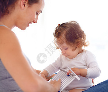 年轻妈妈教她可爱的女婴怎么用算盘 (Abacus)图片