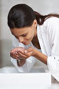 一个年轻女子在河盆洗脸 她的表情很纯洁 很干净图片