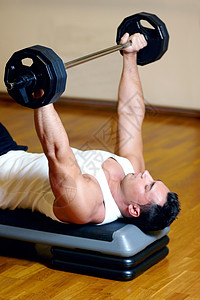 在健身房锻炼运动的健壮运动员 保持他的胸肌的完美形状图片