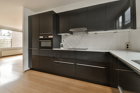 一个有黑柜子和木地板的厨房公寓房间沙发奢华内阁自助餐黑色装饰柜台房子图片