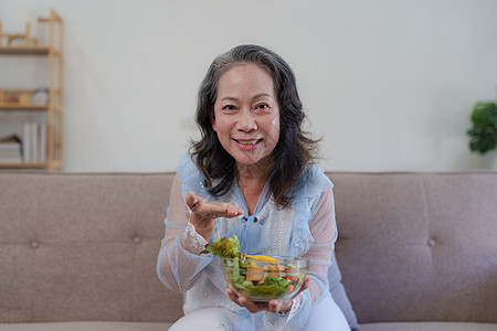 享受新鲜绿色沙拉的年老女性快乐 高龄女性在家里身体健康 锻炼和健康的饮食概念沙拉厨房午餐男人家庭桌子夫妻祖母老年水果图片