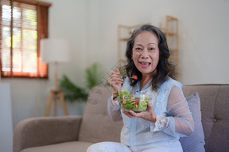 享受新鲜绿色沙拉的年老女性快乐 高龄女性在家里身体健康 锻炼和健康的饮食概念微笑蔬菜烹饪夫妻成人退休男人老年沙拉午餐图片