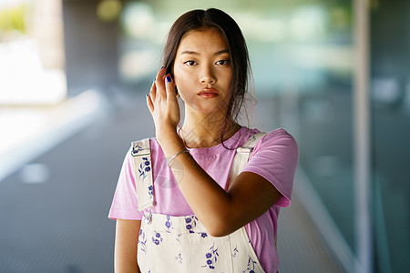 年轻的亚洲女性触摸头发高清图片