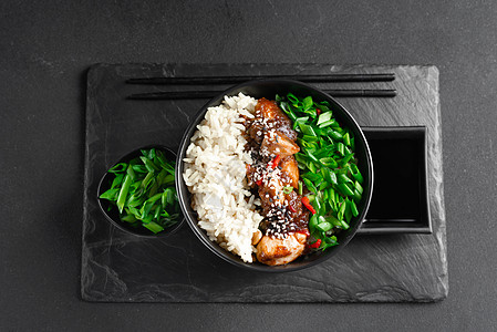 红烧鸡肉饭碗 - 亚洲美食风格 亚洲食品 泰国美食 深色背景中的鸡肉和大葱米饭 中国菜 米饭与辣宫保鸡丁放在盘子里 从上面的水平图片