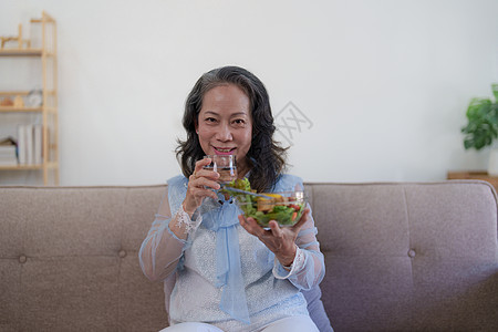 享受新鲜绿色沙拉的年老女性快乐 高龄女性在家里身体健康 锻炼和健康的饮食概念桌子家庭夫妻午餐微笑成人烹饪退休厨房蔬菜图片
