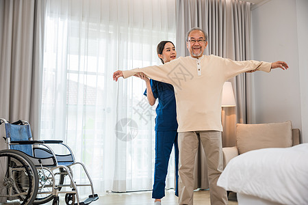老人喜欢在家接受物理治疗师的伸展双臂训练助手身体老年专家医院运动肩膀长老医生男人图片