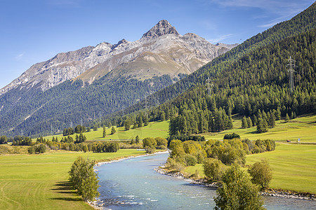 日出时在恩加丁谷的阿尔卑斯河瑞士格里森风景耀斑天堂全景蓝色假期草地溪流旅行文化图片